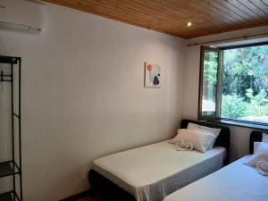 two beds in a room with a window at Gerês by Papitravel in Vieira do Minho