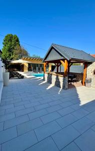 a patio with a gazebo next to a building at Villa SARA Bugojno in Bugojno