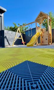 a playground with a slide and a swing set at Villa SARA Bugojno in Bugojno