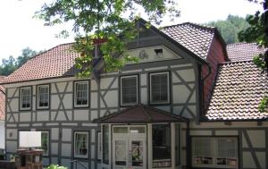 a black and white house with a roof at Hotel Restaurant Rodetal in Nörten-Hardenberg