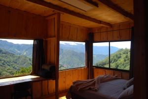 a bedroom with four windows in a wooden house at Calcopirita Stay House in Rivas
