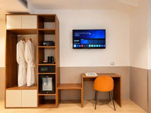 a room with a desk and a tv on a wall at Lh HOTELS in Milan