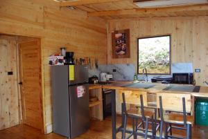a kitchen with a refrigerator and a counter with chairs at Calcopirita Stay House in Rivas