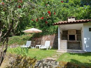 a couple of chairs and an umbrella in a yard at Gerês by Papitravel in Vieira do Minho
