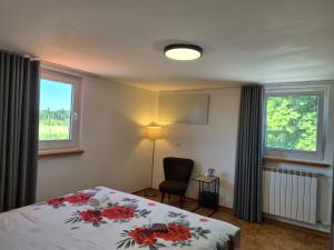a bedroom with a bed with red flowers on it at Apartmaji I&E in Sežana