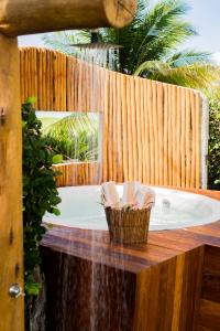a bathroom with a tub with a wooden fence at Villa Cote Sud Pousada De Charme - Pé na Areia in São Miguel dos Milagres