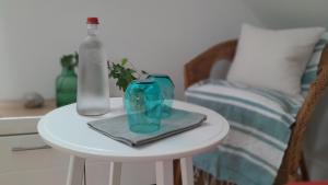 a table with a glass vase and a bottle on it at Quiétude au Bord de Loire. in Orléans