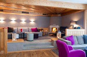 a living room with couches and a fireplace at Hotel Rosatsch Residence in Pontresina