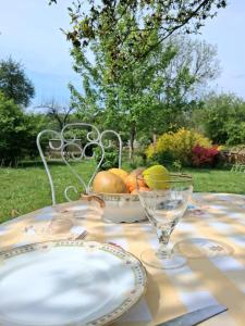 a table with a plate and a bowl of fruit at LE LIT DE LA SEMOY Chassepierre in Chassepierre