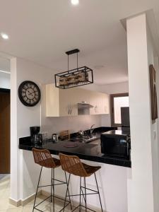 a kitchen with a counter and two bar stools at Asilah in Asilah