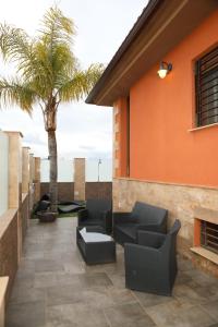 a patio with couches and a palm tree at Villa de Lujo con Piscina A 5 min de San Juan de los Terreros in Pulpí