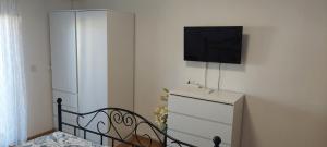 a bedroom with a dresser and a tv on a wall at Apartment Grapevine in Kornić