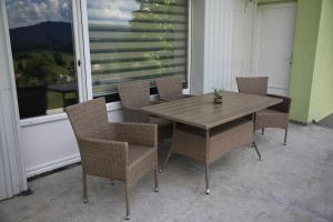 a table and chairs on a porch with a window at Vila Zeleno borje in Žabljak +15 photos