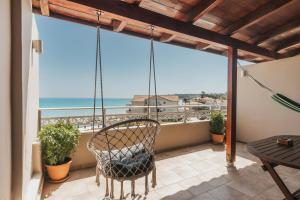 a balcony with a chair and a view of the ocean at Boho Sea View Studio in Planos