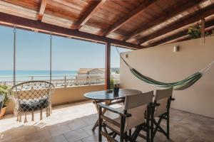 a balcony with a table and chairs and a view of the ocean at Boho Sea View Studio in Planos +25 photos