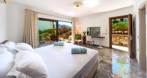 a bedroom with a large white bed and a living room at Kalkan Regency in Kalkan