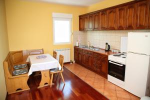a kitchen with a table and a white refrigerator at Vila Zeleno borje in Žabljak