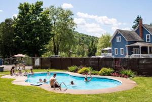 a group of people playing in a swimming pool at Country house with SPA, small beach, pool in Mont-Tremblant