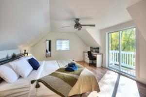 a bedroom with a large bed with a ceiling fan at Country house with SPA, small beach, pool in Mont-Tremblant +32 photos