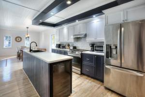 a kitchen with a stainless steel refrigerator and a counter at Country house with SPA, small beach, pool in Mont-Tremblant