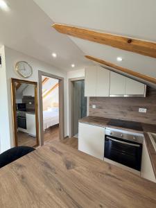 a kitchen with white cabinets and a counter top at Apartman Lucija 5 in Zubovići