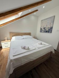 a bedroom with a large bed with two towels on it at Apartman Lucija 5 in Zubovići