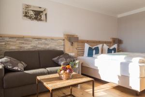ein Wohnzimmer mit einem Sofa und einem Bett in der Unterkunft Hotel Christine in Eisenberg