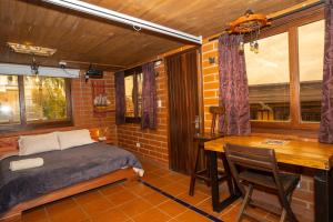 a bedroom with a bed and a desk and a table at Hotel Alto lindo in Guatapé