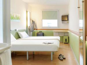 a room with a bed and a sink and a mirror at ibis budget Karlsruhe in Karlsruhe