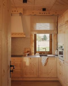 a kitchen with wooden cabinets and a window at Lovelia Luxury Chalet & Jacuzzi in Zakopane