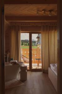 a bathroom with a tub and a view of a patio at Lovelia Luxury Chalet & Jacuzzi in Zakopane +84 photos