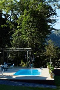 a swimming pool with a fountain in a yard at Pousada Rancho da Serra PETAR in Iporanga