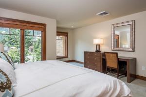 a bedroom with a bed and a desk and a mirror at Chilali 25 in Ketchum