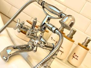 a chrome bathroom sink faucet in a bathroom at Maison VCB Ciney - Hôtel Particulier de 1820, Cœur de Ville, Parc & Parking Privé in Ciney