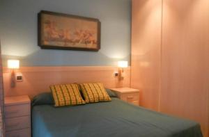 a bedroom with a bed and a painting on the wall at PRIMERA LINEA DE PLAYA VILAFORTUNY in Vilafortuny +12 photos