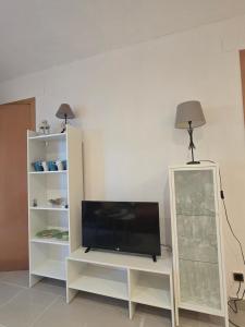 a flat screen tv sitting on a white entertainment center at PRIMERA LINEA DE PLAYA VILAFORTUNY in Vilafortuny