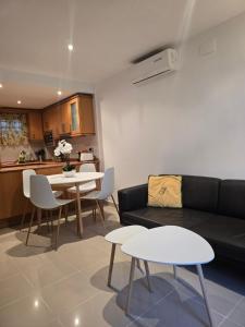 a living room with a couch and tables and a kitchen at PRIMERA LINEA DE PLAYA VILAFORTUNY in Vilafortuny