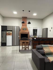 a living room with a couch and a brick fireplace at Recanto R2V in Chapada dos Guimarães