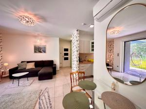 a living room with a couch and a mirror at Fűzliget2- Green Lake in Balatonfůzfő