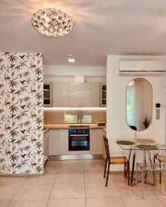 a kitchen with a table and chairs and a chandelier at Fűzliget2- Green Lake in Balatonfůzfő