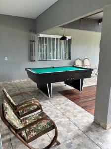 a pool table and a chair in a living room at Recanto R2V in Chapada dos Guimarães