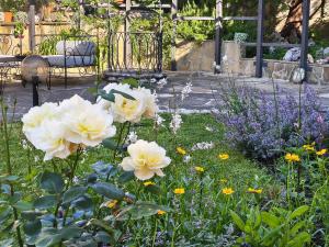 a garden with white flowers and a bench in the background at Motivi Hotel in Saints Constantine and Helena