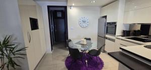 a kitchen with a glass table with chairs and a clock at Apartman Jo Ma MA in Solin +24 photos