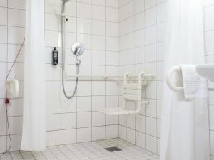 a bathroom with a shower with a shower curtain at ibis Stuttgart Centrum in Stuttgart +86 photos