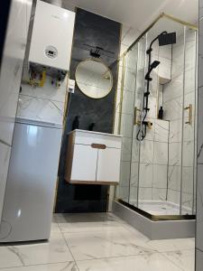 a white bathroom with a sink and a shower at Imperial Apartament in Gniezno
