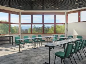 a conference room with tables and chairs and windows at Mercure Jelenia Góra in Jelenia Góra