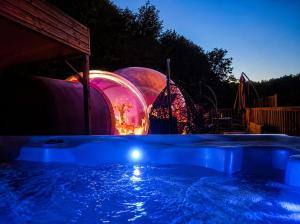 a swimming pool at night with domes in the background at La Bulle Des Anges in Illoud
