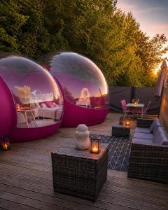 two domes on a deck with furniture and lights at La Bulle Des Anges in Illoud