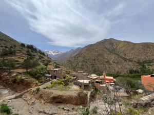 a village in the mountains with mountains in the background at Adrar view lodge in Imlil