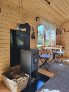 a living room with a stove and a table at Glamping Maringotka77 in Protivec